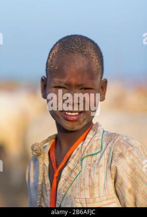 Porträt eines Mundai-Stammjungen, der mit Asche bedeckt ist, um Fliegen und Stechmücken in einem Viehlager, Central Equatoria, Terekeka, Südsudan abzuwehren Stockfoto