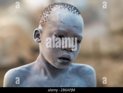 Porträt eines Mundai-Stammjungen, der mit Asche bedeckt ist, um Fliegen und Stechmücken in einem Viehlager, Central Equatoria, Terekeka, Südsudan abzuwehren Stockfoto