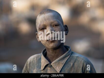 Porträt eines Mundai-Stammjungen, der mit Asche bedeckt ist, um Fliegen und Stechmücken in einem Viehlager, Central Equatoria, Terekeka, Südsudan abzuwehren Stockfoto