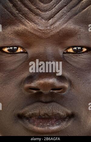 Nahaufnahme einer mundarischen Stammfrau mit Schikanen auf der Stirn, Central Equatoria, Terekekka, Südsudan Stockfoto