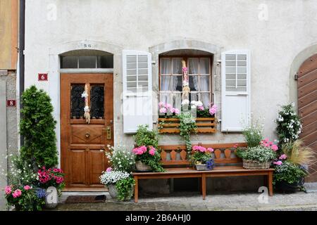 Gruyeres, SCHWEIZ - 8. JULI 2014: Haustür zum Schweizer Traditionshaus. Das malerische Haus liegt an der Kopfsteinpflaster Hauptstraße in der Altstadt von Gruyer Stockfoto