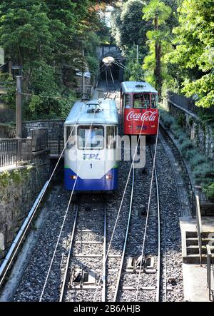 Lugano, SCHWEIZ - 5. JULI 2014: Zwei Standseilwagen fahren in Lugano aneinander vorbei. Die Funicolare Lugano Città-Stazione ist eine kurze Verbindungsstrecke mit t Stockfoto