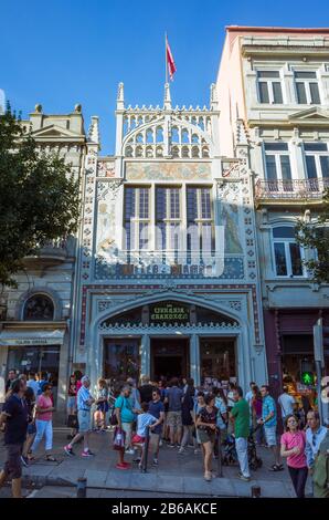 Porto, Portugal - 27. Juli 2018: Touristen gehen außerhalb der Lello-Buchhandlung, die 1869 in der Rua das Carmelitas 144 gegründet wurde und als eine der vielen gilt Stockfoto