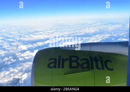 Riga, Lettland - 22. April 2019: Blick vom Flugzeugfenster auf die Turbine. Baltisches Flugzeug, das über die Wolken fliegt Stockfoto