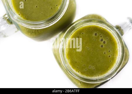 Gesunder grüner Smoothie im Mixbecher isoliert auf weißem Hintergrund. Draufsicht. Stockfoto