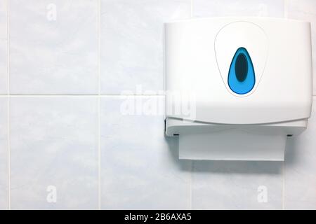 Softfocus-Papierhandtuchspender an einer Wand aus Granit im Badezimmer. Papierhandtuch in der Toilette. Sauber und hygienisch Stockfoto