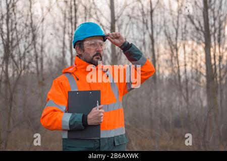 Forsttechniker posiert in Wald mit Merkzettel für die Sammlung von Daten Stockfoto