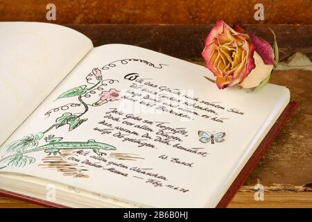 Poesiealbum mit altem Buch und Rose Stockfoto