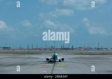 Flugzeug auf der Start- und Landebahn des Flughafens Singapur unter dramatischem Himmel Stockfoto
