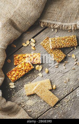 Mischung aus Gozinaki-Saatkrähen auf Vintage-Hintergrund mit Burlap. Köstliche orientalische Süßigkeiten aus den Samen von Sonnenblumen, Sesam und Erdnüssen, bedeckt Stockfoto