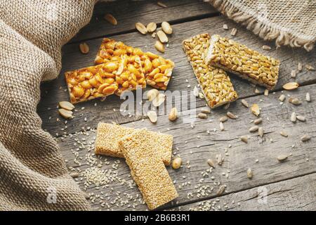 Mischung aus Gozinaki-Saatkrähen auf Vintage-Hintergrund mit Burlap. Köstliche orientalische Süßigkeiten aus den Samen von Sonnenblumen, Sesam und Erdnüssen, bedeckt Stockfoto