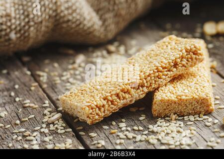 Verschiedene Kozinaki, auf altem Vintage-Hintergrund, mit Burlap-Material. Landhausstil. Köstliche Süßigkeiten aus den Samen von Sonnenblumen, Sesam und Erdnüssen Stockfoto