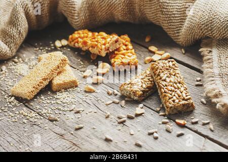 Mischung aus Gozinaki-Saatkrähen auf Vintage-Hintergrund mit Burlap. Köstliche orientalische Süßigkeiten aus den Samen von Sonnenblumen, Sesam und Erdnüssen, bedeckt Stockfoto