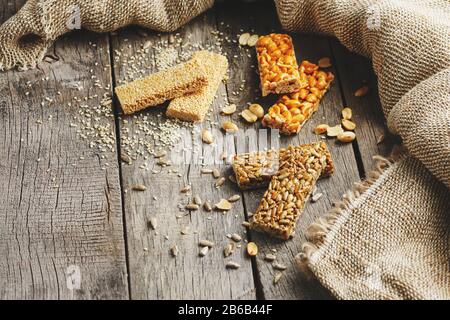 Mischung aus Gozinaki-Saatkrähen auf Vintage-Hintergrund mit Burlap. Köstliche orientalische Süßigkeiten aus den Samen von Sonnenblumen, Sesam und Erdnüssen, bedeckt Stockfoto