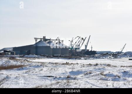 Große Körnerelevatorsilos im Hafen am Hintergrund des Winterschiffs Stockfoto