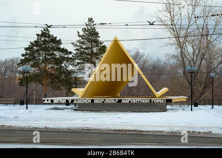 Wahrzeichen von Magnitogorsk, Russland. Das erste Zelt. Denkmal in einer Kleinstadt. Worte: Goldene Lichter brannten an den Türen auf den roten Steinen eines magnetischen m Stockfoto