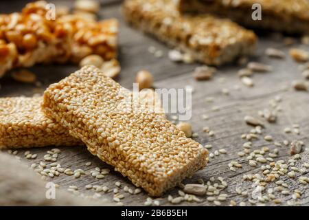 Verschiedene Kozinaki, auf altem Vintage-Hintergrund, mit Burlap-Material. Landhausstil. Köstliche Süßigkeiten aus den Samen von Sonnenblumen, Sesam und Erdnüssen Stockfoto