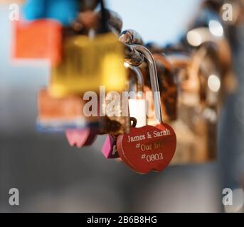Nahaufnahme eines Vorhängeschlocks, das am Kettenglied der Brücke/Des Zauns hängt Stockfoto