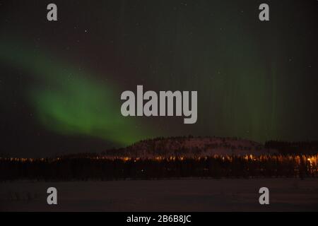 Wunderschöne grüne Nordlichter (Aurora Borealis) in Luosto, Lappland, Finnland mit klarem Himmel und Sternen. Stockfoto