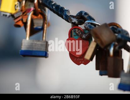Nahaufnahme eines Vorhängeschlocks, das am Kettenglied der Brücke/Des Zauns hängt Stockfoto