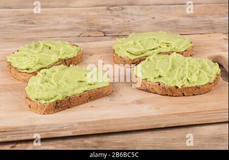 Frische Avocado-Pasta auf Müsli und Cornflakes Brot. Sandwiches mit Avocado-Paste. Gesunder Lebensstil. Nahaufnahme. Stockfoto