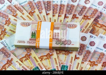 Eine halbe Million russische Rubel verstreut auf dem Tisch. Das Tutu im Bankpaket für die fünftausendsten Rechnungen flattern Stockfoto