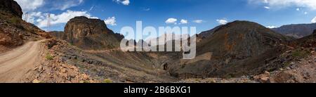 Berg- und Talblick entlang der Wadi Sahtan Straße und Schlangenschlucht in Al Hajir Bergen zwischen Nizwa und Mascat im Oman Stockfoto