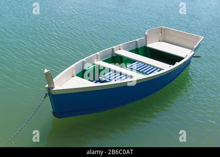 Strahlend blaues Ruderboot auf dem smaragdgrünen Wasser des Sees. Sonniger Tag zum Skifahren Stockfoto