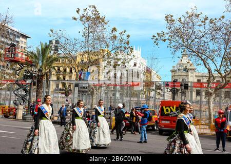 Weibliche Vertreter des Fallas-Festivals (Falleras) paradieren am Rathausplatz vor dem traditionellen Tagesfeuerwerk (Mascleta). Stockfoto