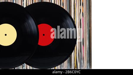 Zwei schwarze Schallplatten mit Farbetiketten vor dem Regal vieler dicht stehender Vinyl-Platten in alten Farbabdeckungen über weißem Hintergrund-Studiofoto Stockfoto