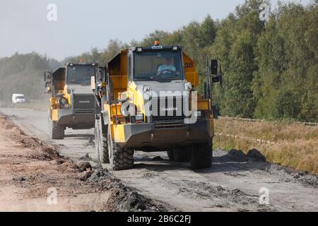 Komatsu-Muldenkipper nehmen Backfill entlang einer Haustraße auf einem neuen Straßenbau in Doncaster, der als Great Yorkshire Way bekannt ist Stockfoto