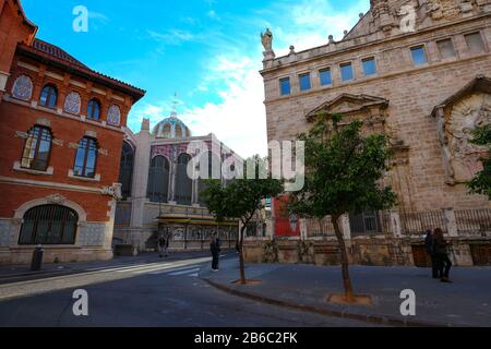 Straßenszene im historischen Valencia, Spanien, mit der Kirche Església de Sant Joan del Mercat und dem Zentralmarktgebäude. Stockfoto