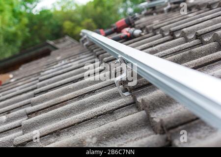 Nahaufnahme der Montageschiene für die Fotovoltaikanlage auf dem Dachgebäude Stockfoto