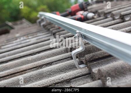 Nahaufnahme der Montageschiene für die Fotovoltaikanlage auf dem Dachgebäude Stockfoto