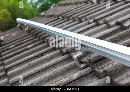 Nahaufnahme der Montageschiene für die Fotovoltaikanlage auf dem Dachgebäude Stockfoto