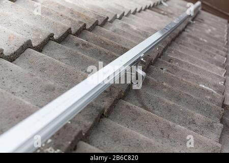 Nahaufnahme der Montageschiene für die Fotovoltaikanlage auf dem Dachgebäude Stockfoto