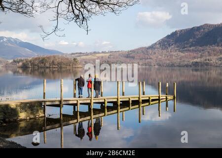 Ein Familienblick über Derwent Water (Cumbria) vom Aussichtspunkt einer Holzlandungsbühne im März 2020. Stockfoto