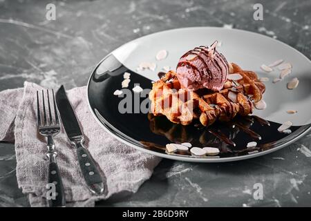 Wiener Waffeln mit Eis und Kaffee. Wunderschönes Dessertbild mit Lettenkaffee. Dessertkonzept, süßes Leben. Lebensmittelfoto, Kopierbereich, grau Stockfoto