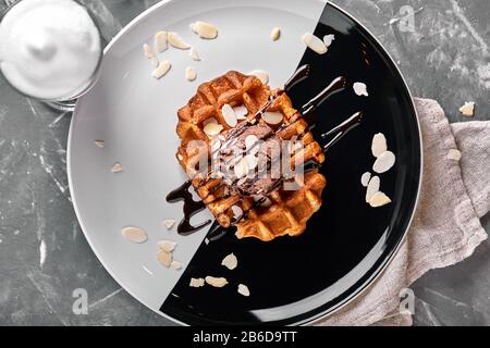 Wiener Waffeln mit Eis und Kaffee. Wunderschönes Dessertbild mit Lettenkaffee. Dessertkonzept, süßes Leben. Lebensmittelfoto, Kopierbereich, grau Stockfoto