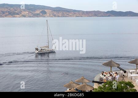 Segelboot und Leute speisen in einem Restaurant im Freien auf der Insel Hydra, Griechenland Stockfoto