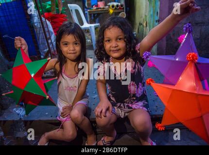 Ein philippinisches Mädchen, das eine Laterne auf einem Weihnachtsmarkt in Las Pinas Stadt, Manila auf den Philippinen hält Stockfoto