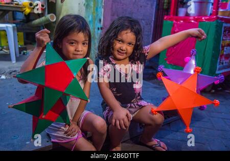 Ein philippinisches Mädchen, das eine Laterne auf einem Weihnachtsmarkt in Las Pinas Stadt, Manila auf den Philippinen hält Stockfoto