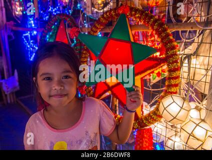 Philippinisches Mädchen mit einer Laterne auf einem Weihnachtsmarkt in Las Pinas Stadt, Manila auf den Philippinen Stockfoto