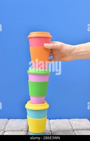 Die Hand einer Frau, die eine Öko-Kaffeetasse mitnimmt. Null-Abfall-Konzept. Stockfoto