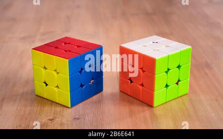 Mehrere Rubik-Würfel intelligente Spielzeuge gelöst, in einem Holztisch Stockfoto