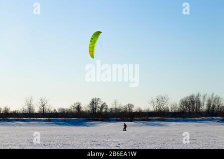 Männer, die Kiteskifahren am Saint Laurent River, La Prairie, Quebec, Kanada. Winterszene Stockfoto