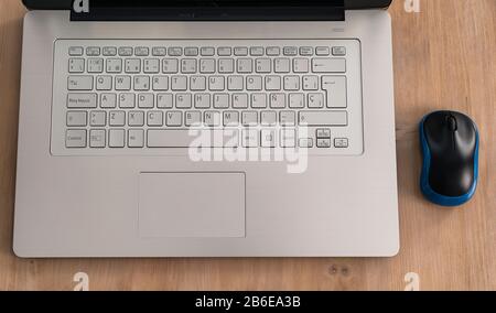 Modernes und Design grauer Notebook-Computer oder Laptop mit Tastatur und schwarzem und blauem Laptop in einem hellen Holztisch Stockfoto