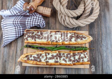 Türkisches Pide mit lang geröstetem und geröstetem Pide. In Steinofen mit Cheddar-Käse gebacken. Türkischer Name; Kazurmali Kasar peynirli pide. Stockfoto