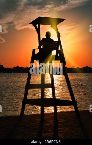 Silhouette eines Rettungsschwimmern bei Sonnenuntergang Stockfoto