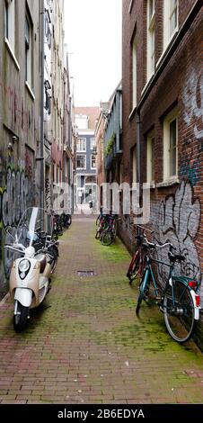 Roller und Fahrräder parkten in einer Straße, Amsterdam, Niederlande Stockfoto